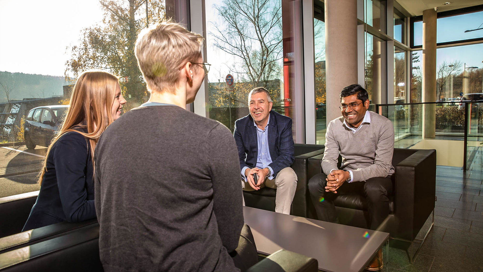 imc employees sitting on couch and talking