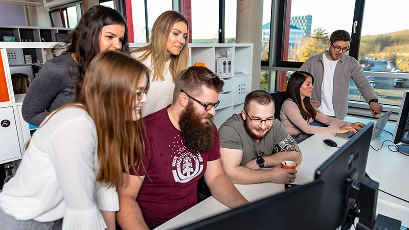 visual designers gathered around a computer