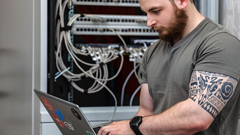 it specialist with laptop infront of server