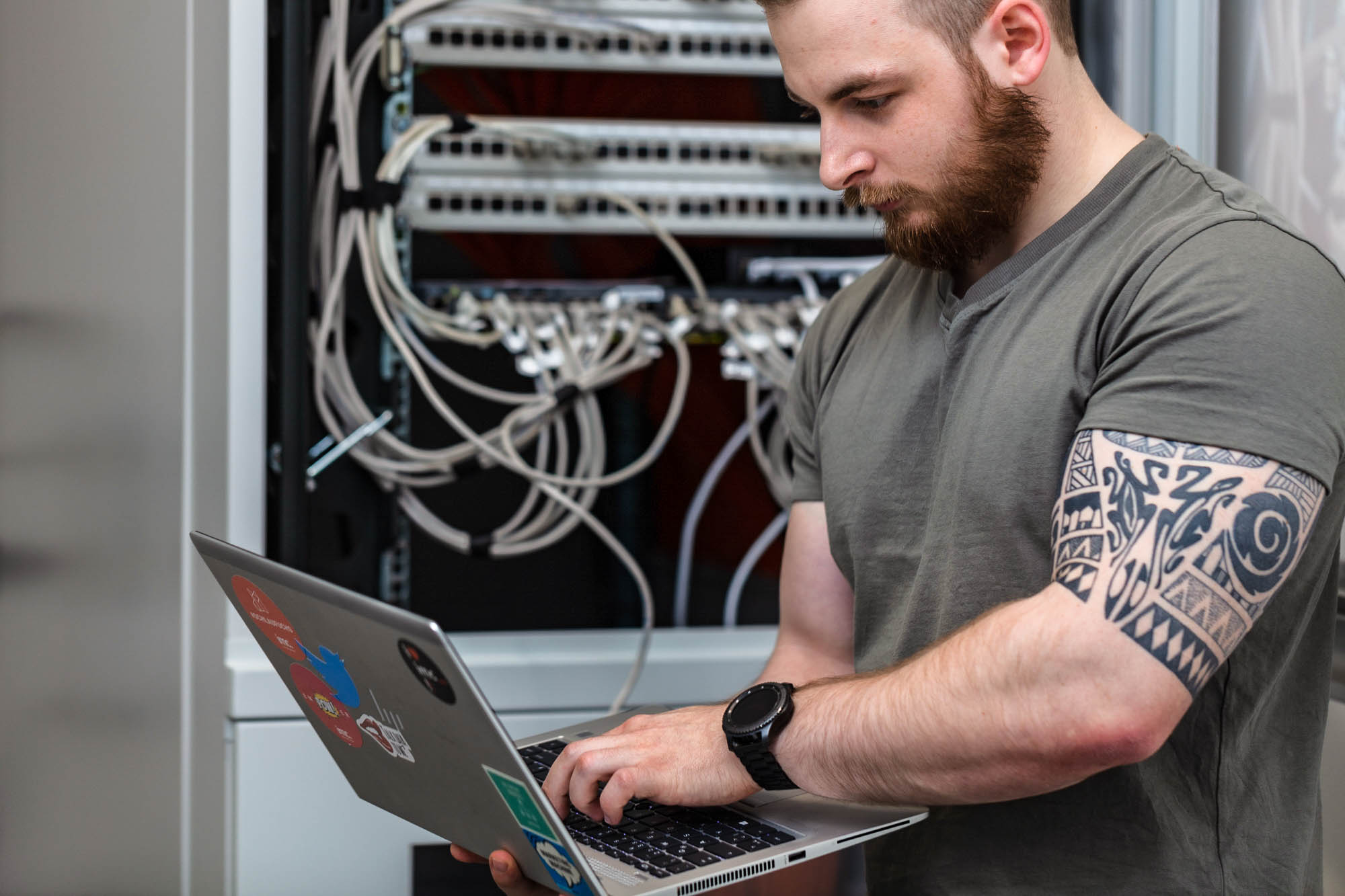 it infrastructure worker on laptop infront of server rack