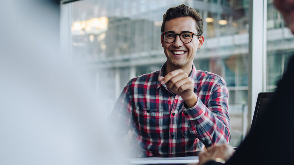 Man in glasses smiling at table