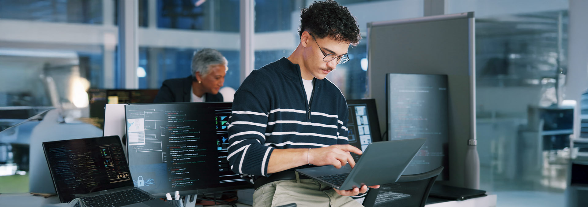 Individual in a tech office, typing on their laptop